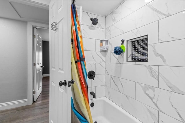 full bathroom with wood finished floors, baseboards, and shower / bath combo