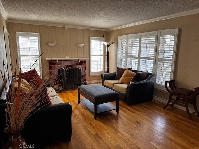 living area with crown molding, wood finished floors, and a healthy amount of sunlight