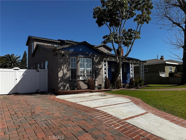 view of front facade with fence, a front yard, and a gate