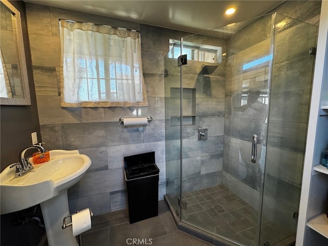 full bathroom featuring tile patterned floors, a shower stall, and tile walls