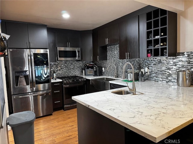 9410 S 4th Ave, Inglewood, CA 90305 - kitchen featuring a peninsula, dark cabinetry, light wood-style floors, stainless steel appliances, and a sink