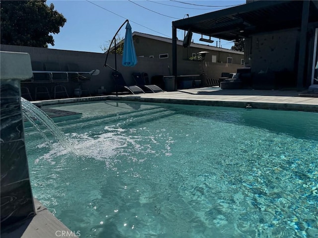 pool with a patio and fence