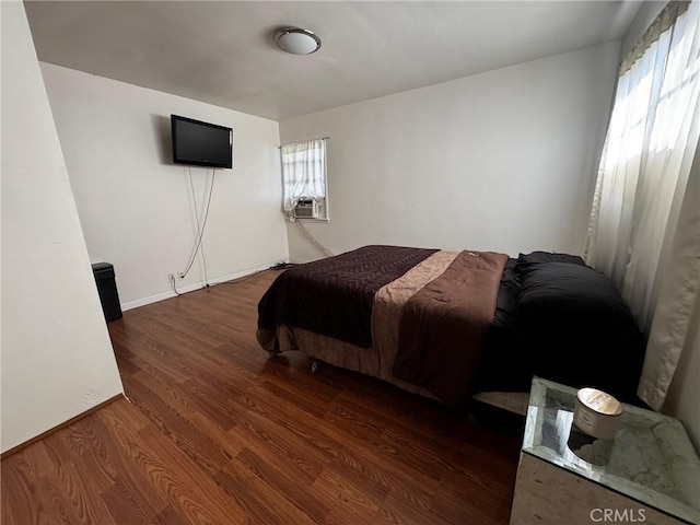 bedroom featuring cooling unit, wood finished floors, and baseboards