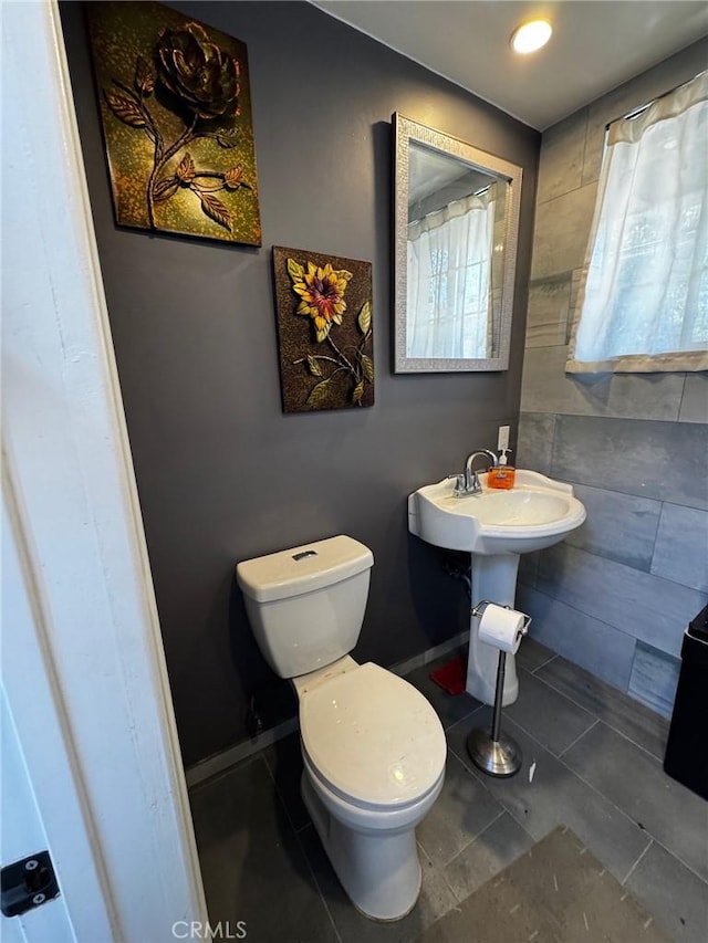 bathroom with tile patterned flooring, toilet, and baseboards