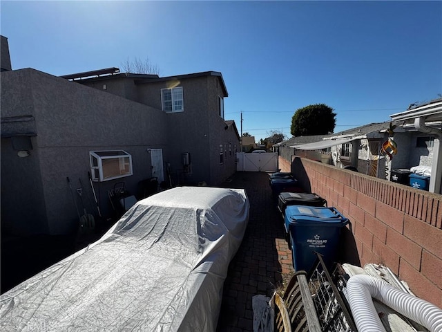 view of side of property with fence and stucco siding