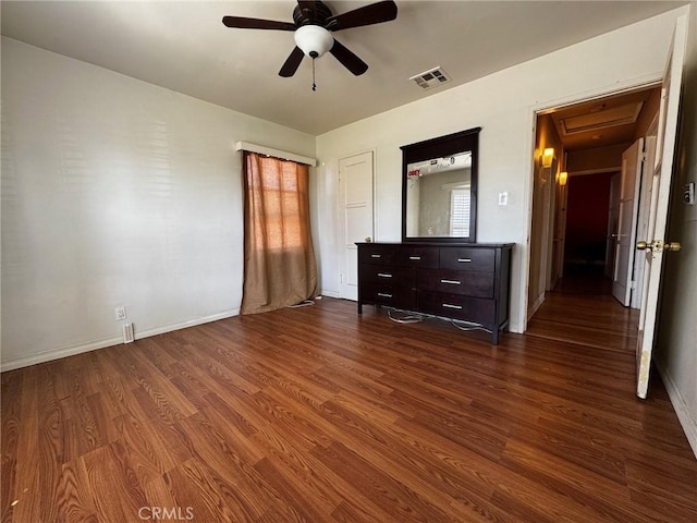 unfurnished bedroom with dark wood-style floors, visible vents, and baseboards