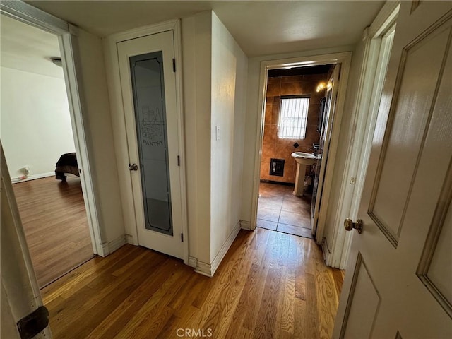 hall featuring baseboards and light wood-style flooring