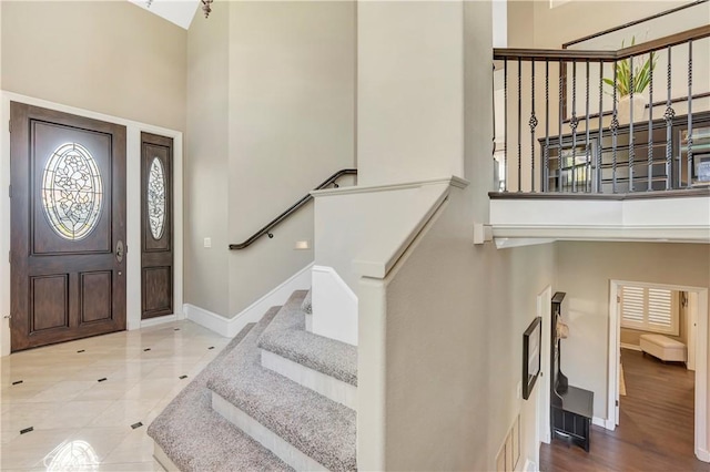 entrance foyer featuring visible vents, baseboards, and a high ceiling