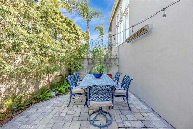 view of patio featuring outdoor dining area and fence