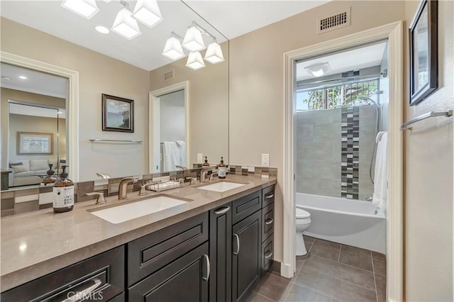 bathroom featuring tile patterned floors, visible vents, toilet, and a sink