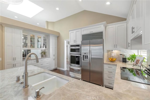 kitchen featuring a sink, a warming drawer, white cabinetry, and stainless steel appliances