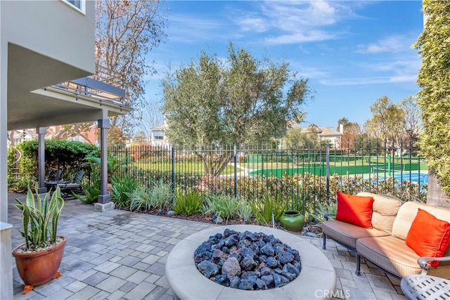 view of patio featuring an outdoor living space with a fire pit and fence