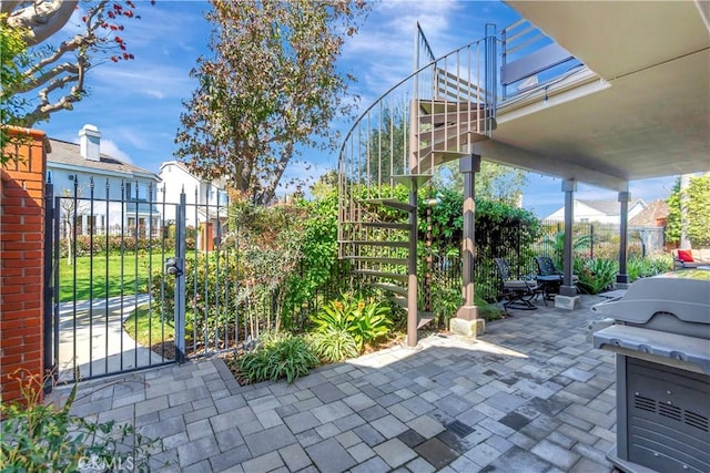 view of patio / terrace with a gate, a grill, and fence