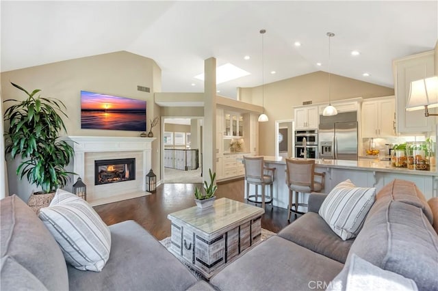 living room with visible vents, high vaulted ceiling, dark wood-style floors, recessed lighting, and a fireplace