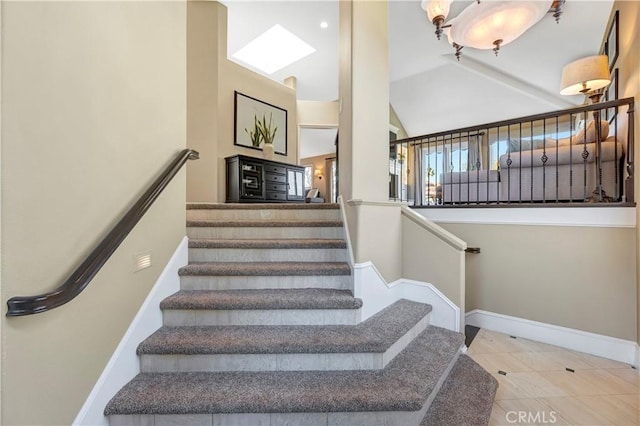 stairway with tile patterned flooring, lofted ceiling, and baseboards