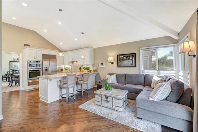 living area with lofted ceiling with beams, recessed lighting, dark wood-type flooring, and visible vents