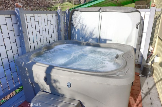 view of patio featuring fence and a hot tub