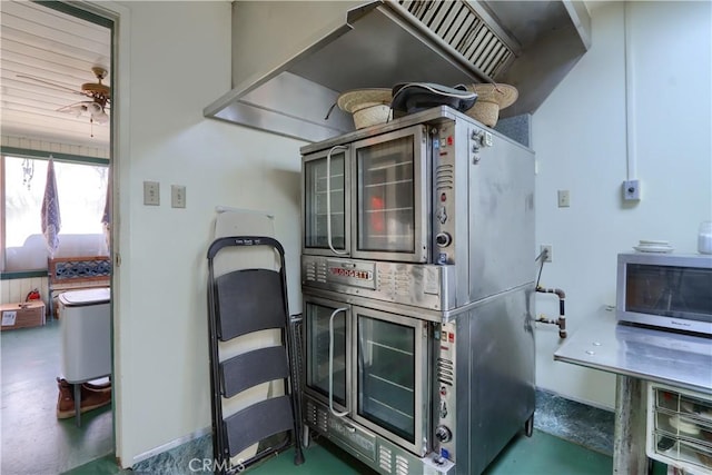 kitchen featuring baseboards, stainless steel microwave, finished concrete flooring, and a ceiling fan