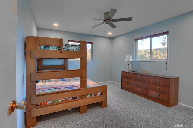 bedroom featuring baseboards, multiple windows, and carpet