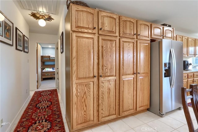 kitchen with light countertops, light tile patterned floors, and stainless steel fridge with ice dispenser