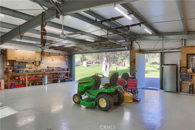 garage with a workshop area and freestanding refrigerator