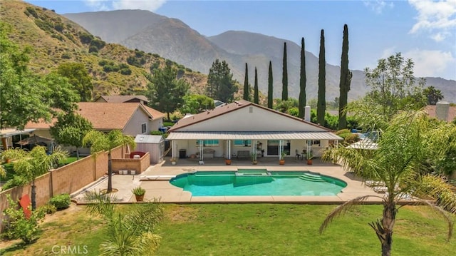 view of swimming pool with a lawn, a fenced backyard, a mountain view, a fenced in pool, and a patio area