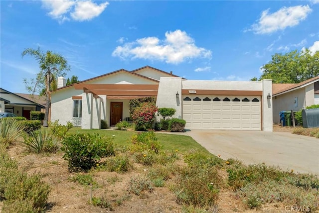 view of front of home with stucco siding, an attached garage, and concrete driveway