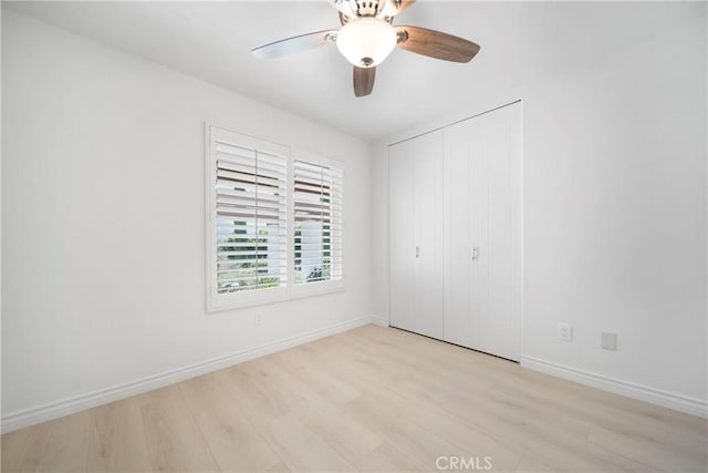 spare room with baseboards, a ceiling fan, and light wood finished floors