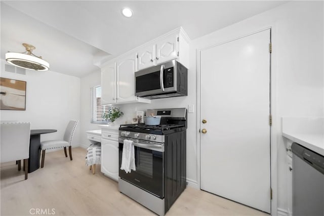 kitchen with baseboards, light wood finished floors, light countertops, white cabinets, and appliances with stainless steel finishes