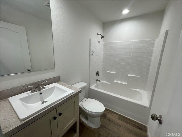 full bath with visible vents, toilet, wood finished floors, bathing tub / shower combination, and vanity