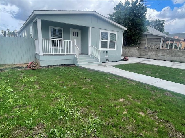 view of front of home featuring a front yard, fence, and covered porch