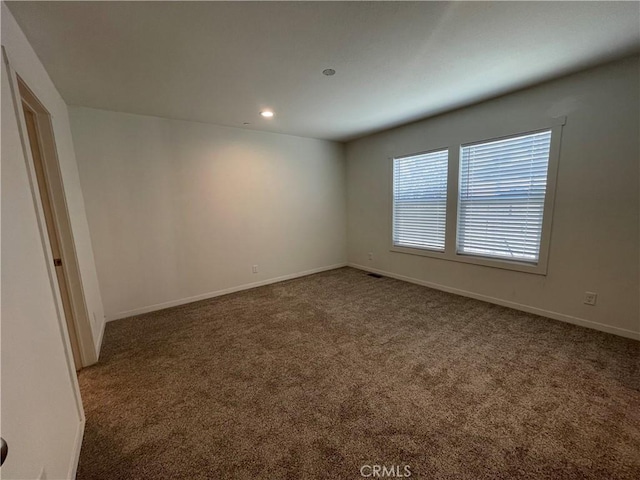 carpeted empty room featuring recessed lighting and baseboards