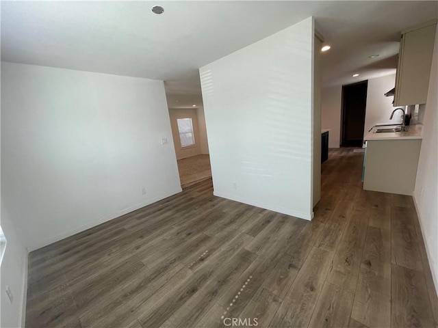 interior space with a sink, baseboards, wood finished floors, and recessed lighting