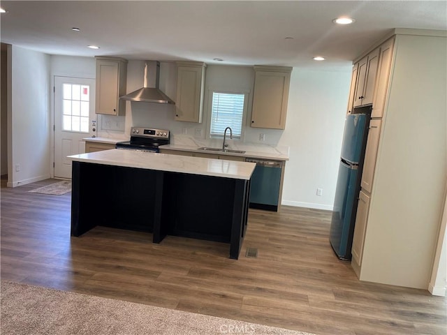 kitchen with plenty of natural light, stainless steel appliances, wall chimney exhaust hood, and a sink