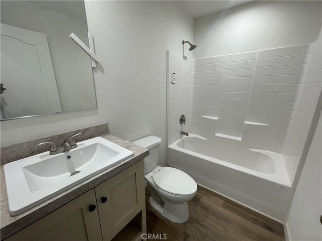 bathroom featuring toilet,  shower combination, wood finished floors, and vanity