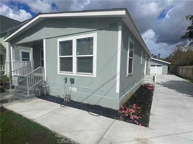 view of side of home with crawl space, an outdoor structure, and fence