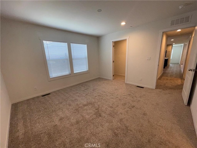 unfurnished bedroom featuring recessed lighting, visible vents, baseboards, and light colored carpet