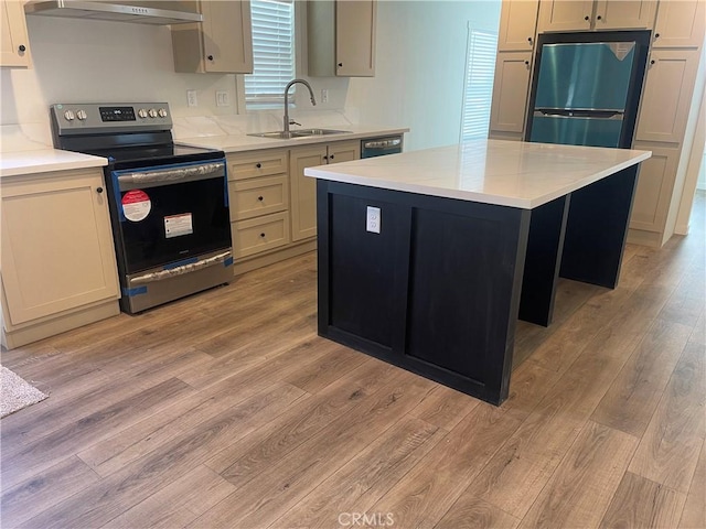 kitchen featuring stainless steel electric range oven, light wood-type flooring, dishwashing machine, fridge, and a sink