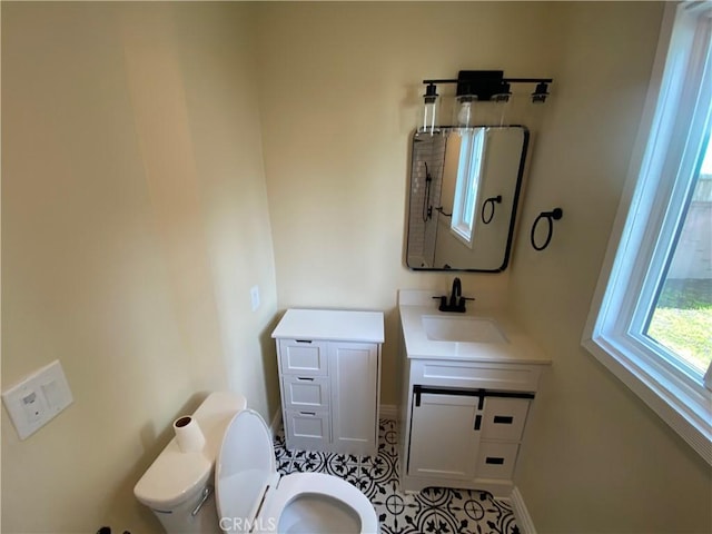 bathroom featuring baseboards, toilet, and vanity