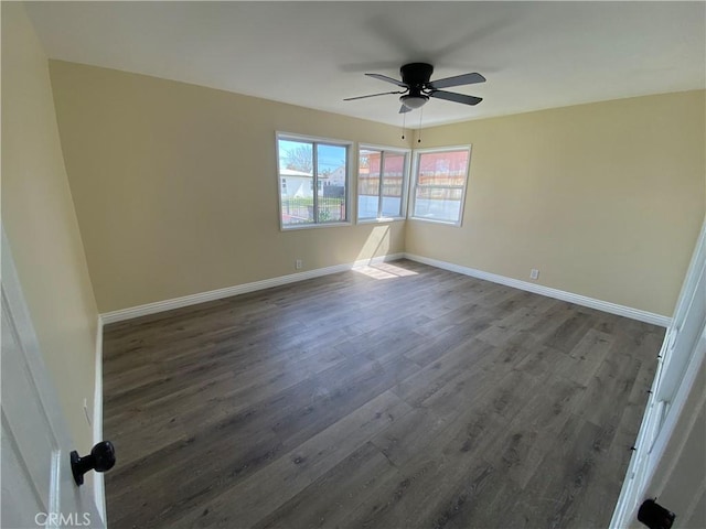 unfurnished room featuring dark wood finished floors, ceiling fan, and baseboards