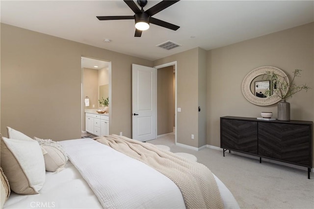 bedroom featuring visible vents, light carpet, a ceiling fan, ensuite bath, and baseboards