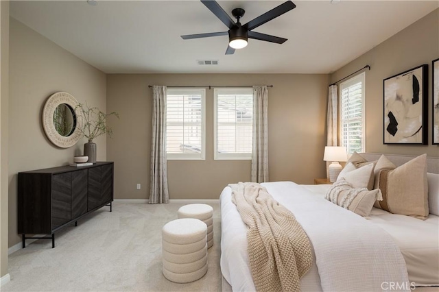 bedroom featuring multiple windows, light colored carpet, and baseboards