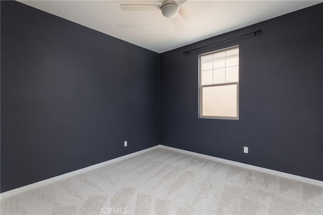 unfurnished room featuring a ceiling fan, baseboards, and light carpet