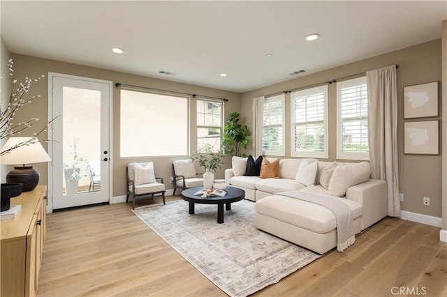 living room with recessed lighting, visible vents, and light wood finished floors