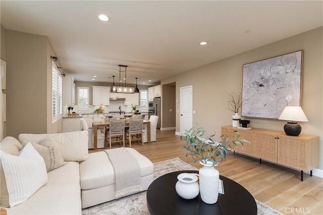 living area with light wood finished floors, recessed lighting, and baseboards