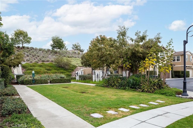 view of community featuring a yard and a garage