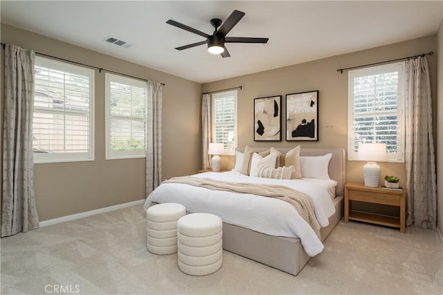 carpeted bedroom with visible vents, a ceiling fan, and baseboards