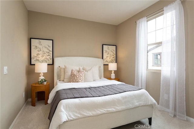 bedroom with light colored carpet and baseboards