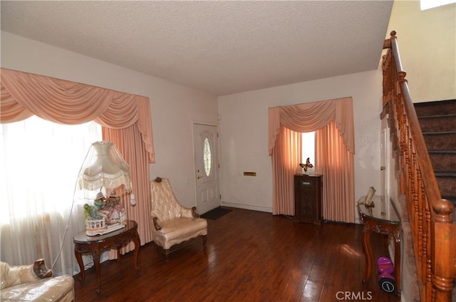 sitting room with a wealth of natural light, a textured ceiling, stairs, and hardwood / wood-style flooring