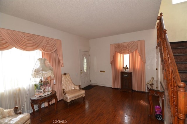 entrance foyer with stairway, a textured ceiling, and hardwood / wood-style floors
